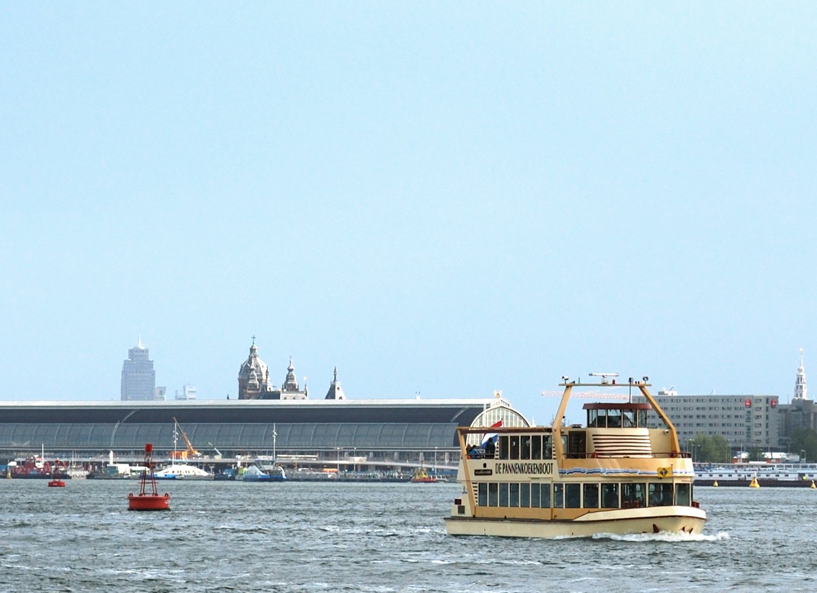 The Pancake Boat on the IJ with the Amsterdam skyline and Central Station behind it