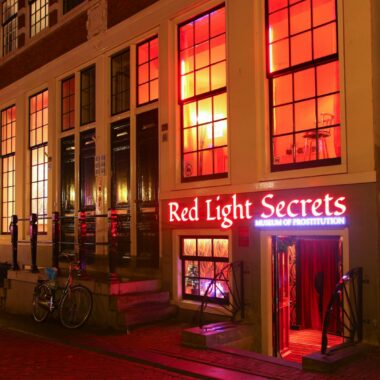 The lit facade of the Red Light Secrets museum on Oudezijds Achterburgwal