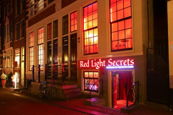 The lit facade of the Red Light Secrets museum on Oudezijds Achterburgwal